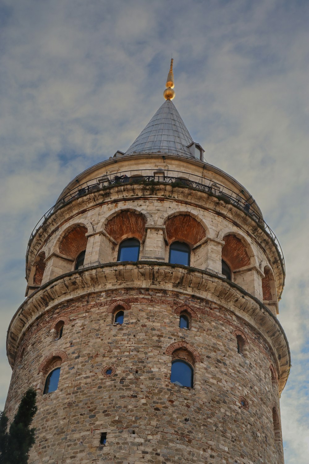 a very tall brick tower with a clock on it's side