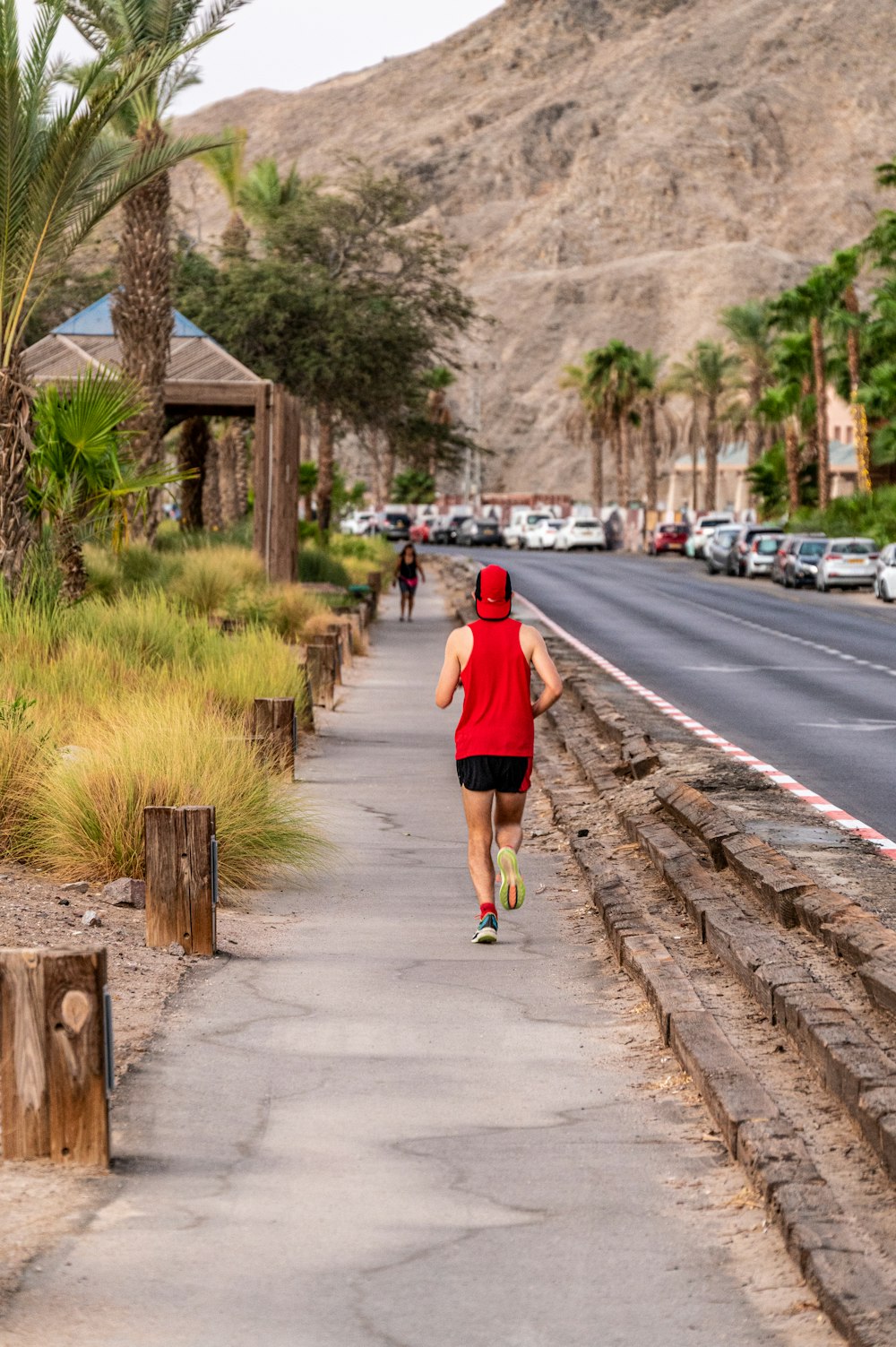 a woman in a red top is running down the street