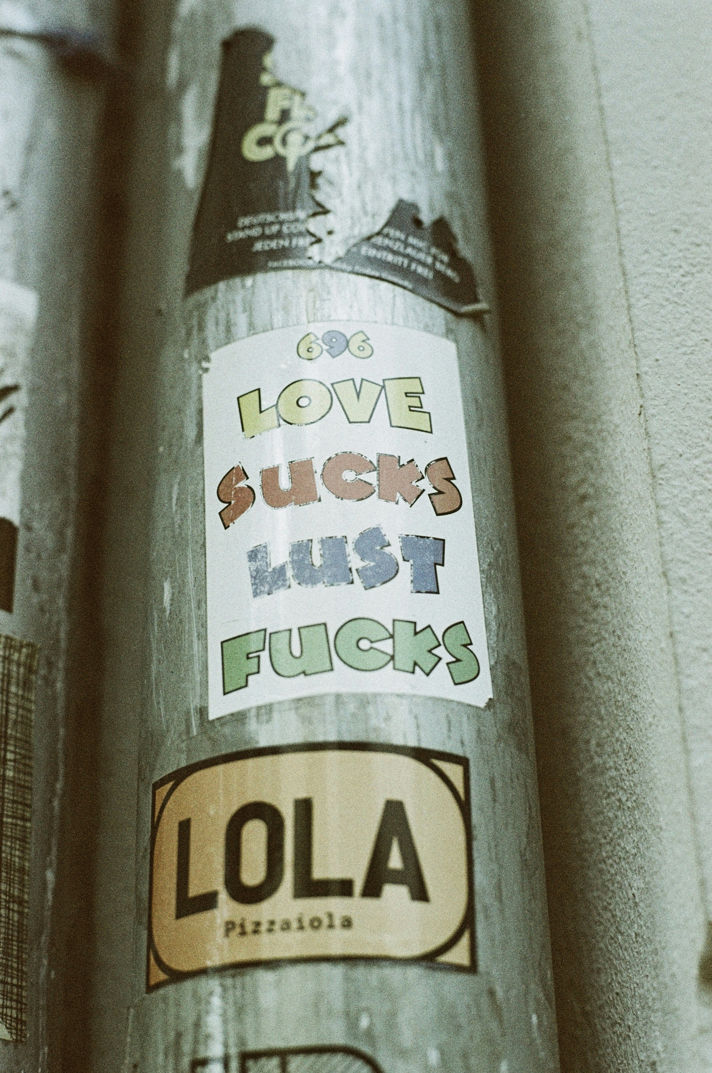 LOVE SUCKS – LUST FUCKS. Urban street art sticker. Leica R7 (1994), Summilux-R 1.4 50mm (1983). Hi-Res analog scan by www.totallyinfocus.com – Lomochrome Metropolis