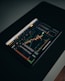 A tablet displaying a detailed digital financial trading interface with various graphs, charts, and numerical data. The screen shows candlestick charts with green and red indicators, illustrating market trends and stock prices.