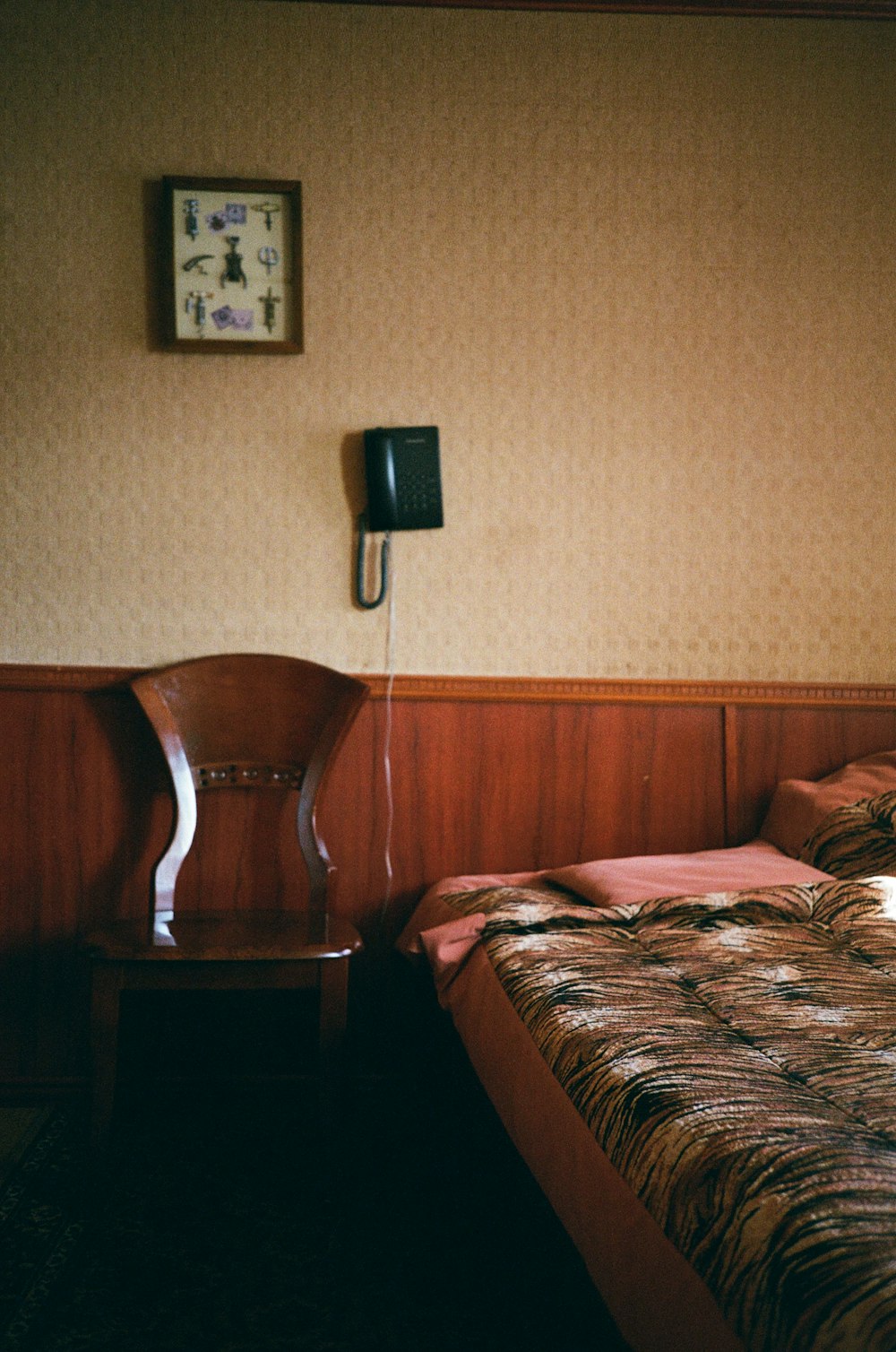 um quarto de hotel com uma cama e um telefone na parede