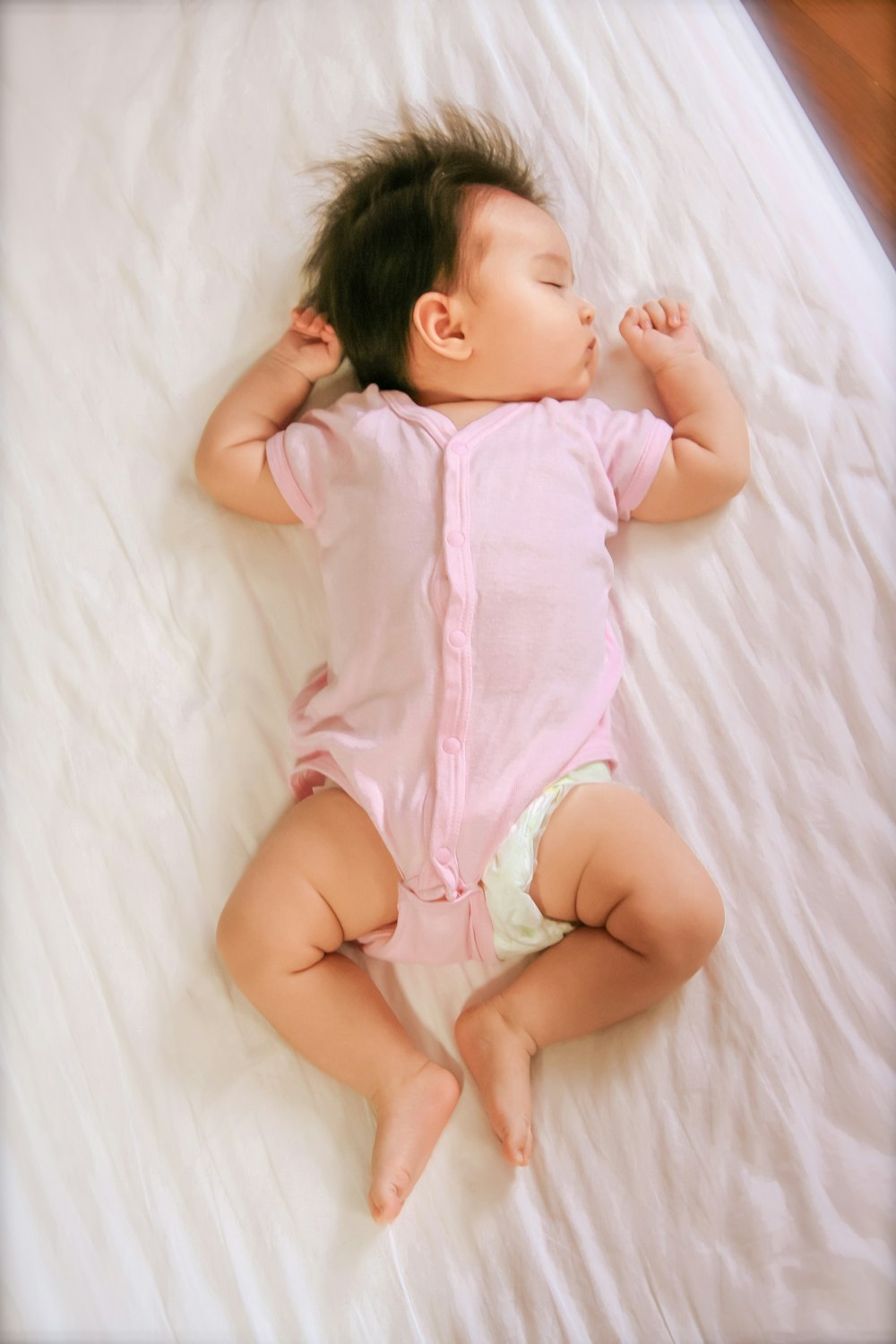 a baby is laying on a white sheet