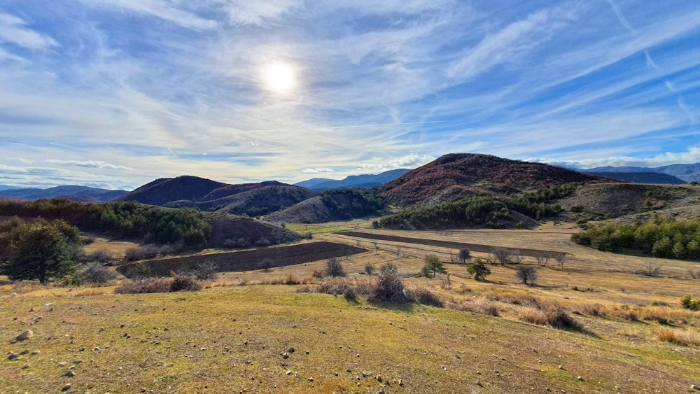 El sol brilla sobre las montañas en la distancia