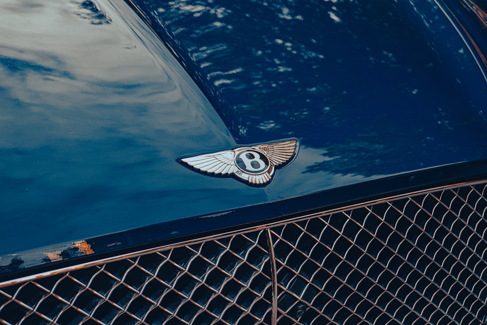a close up of a bentley emblem on a blue car