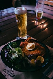 a plate of food and a glass of beer on a table