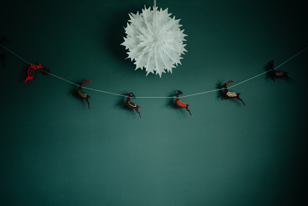 a group of people hanging from a string on a green wall