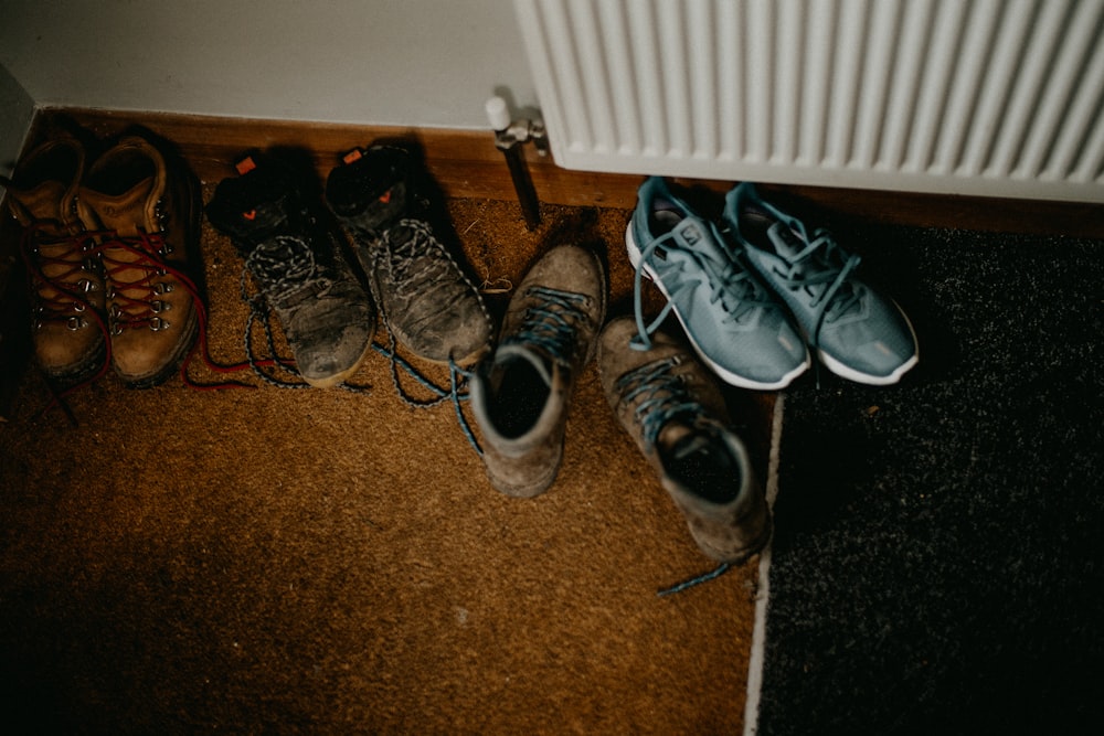 a group of shoes sitting on the floor next to a radiator
