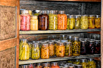 a wooden shelf filled with lots of jars of food