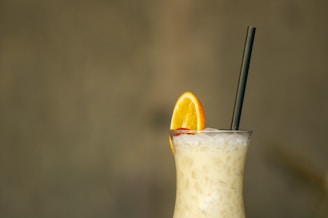 a drink with a straw and an orange slice