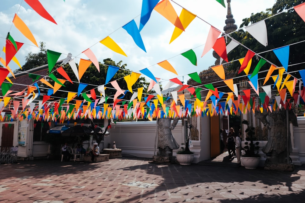 a bunch of colorful flags hanging from a building