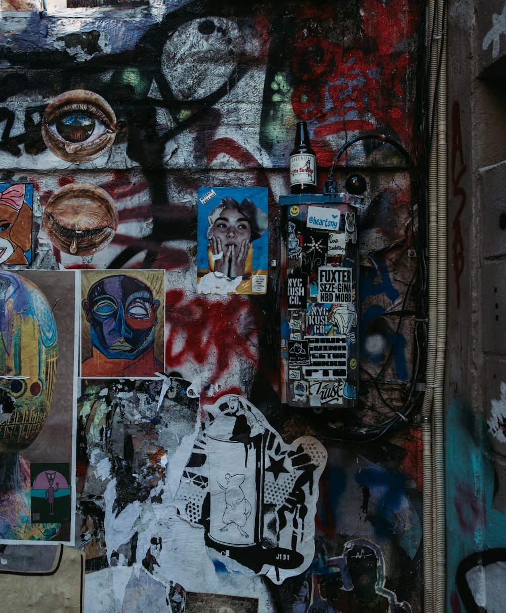 a wall covered in lots of graffiti and stickers