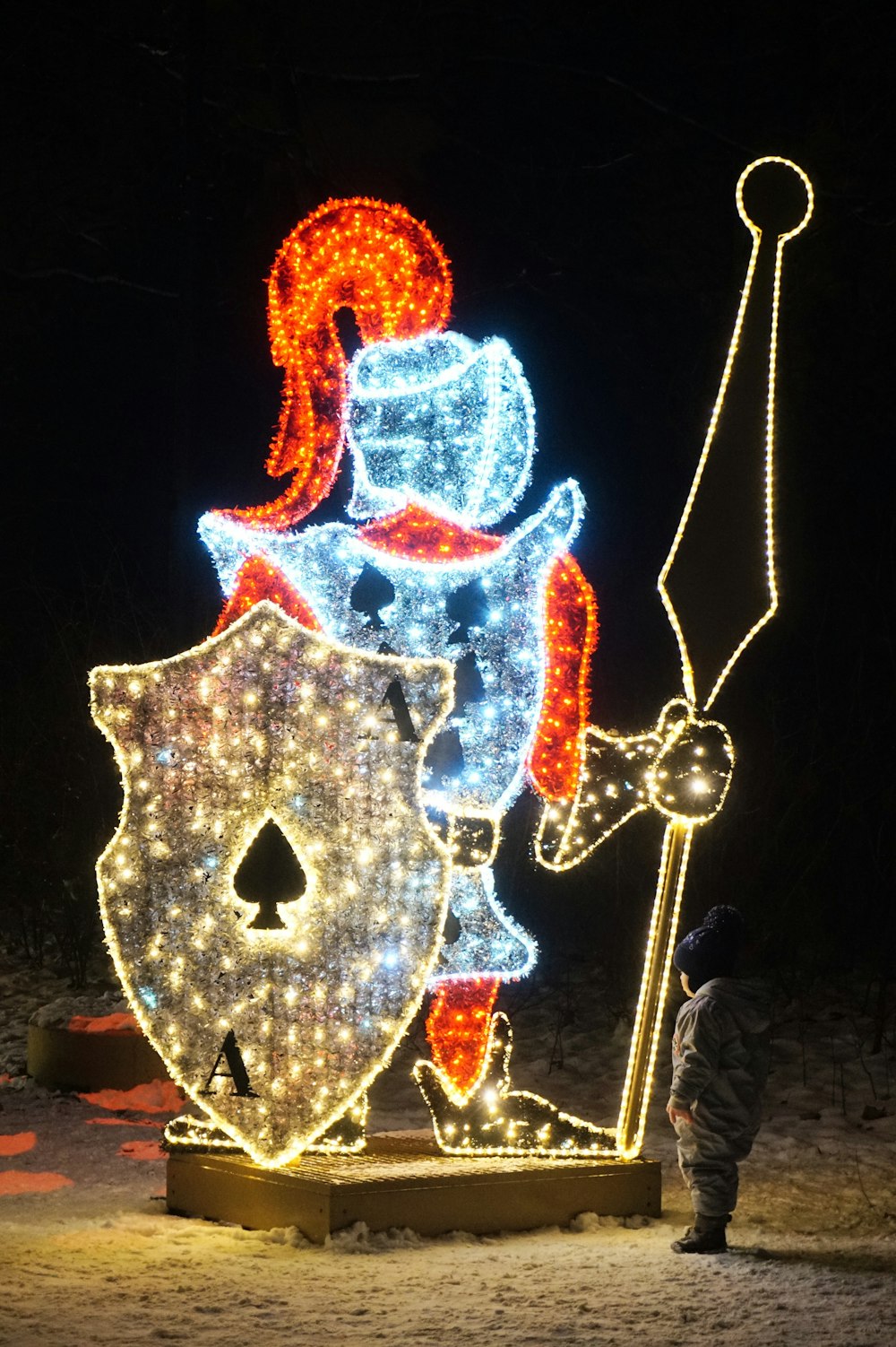 a man standing next to a lit up statue