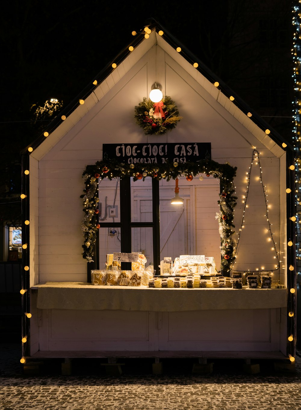 a small white building with christmas lights around it