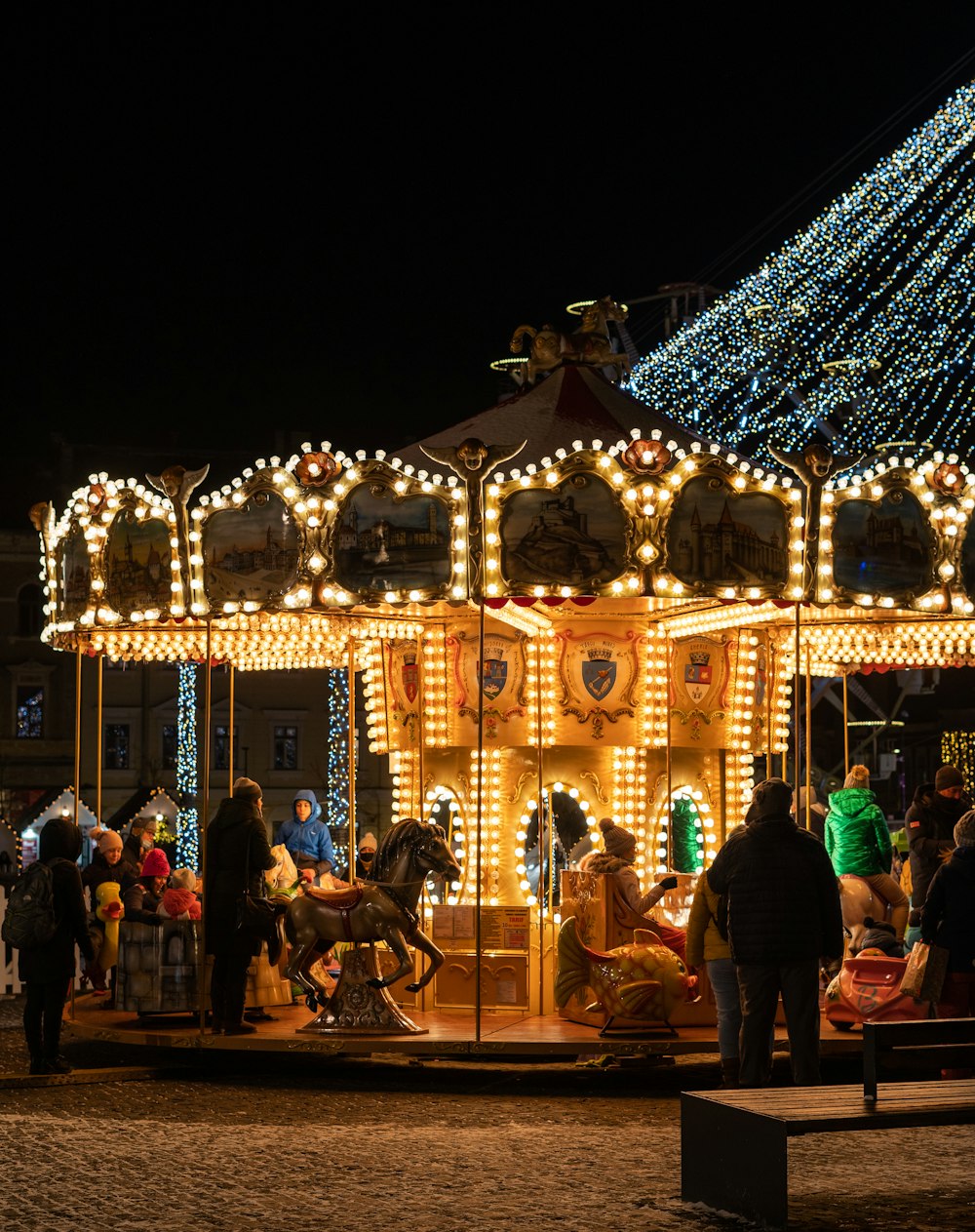 a merry go round at night with people standing around