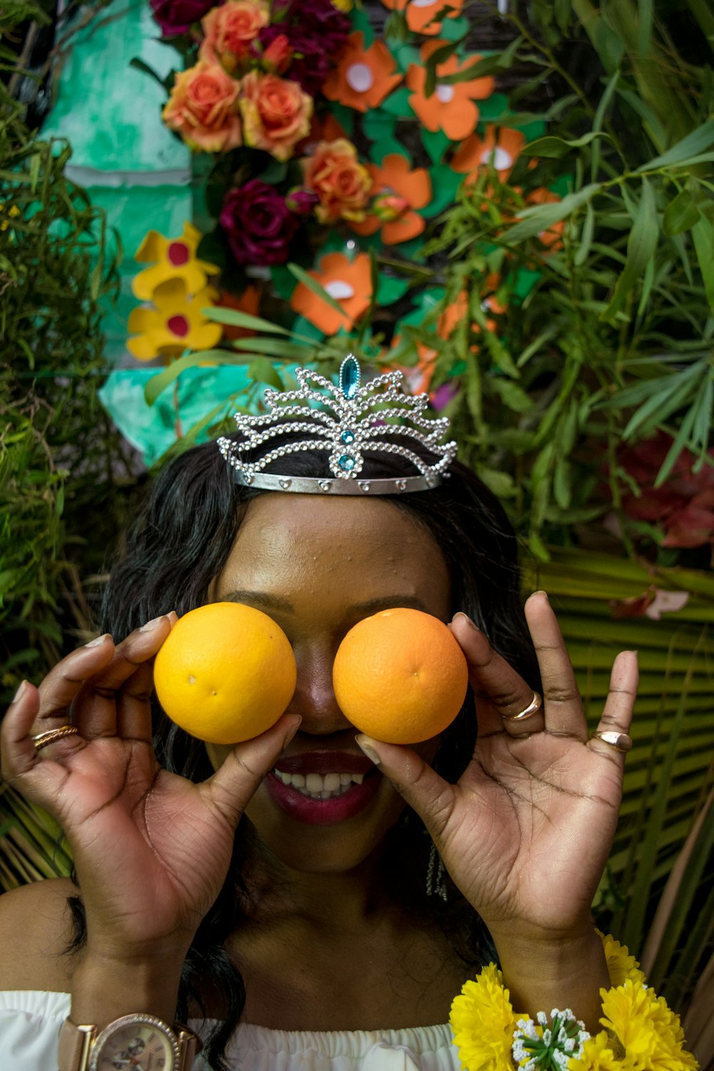a woman holding two oranges in front of her face