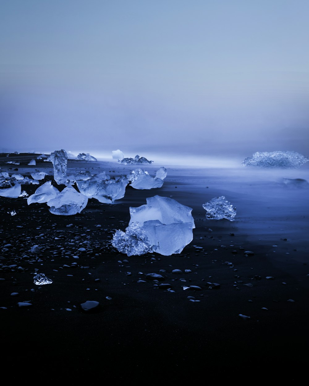 icebergs floating in the water on a beach