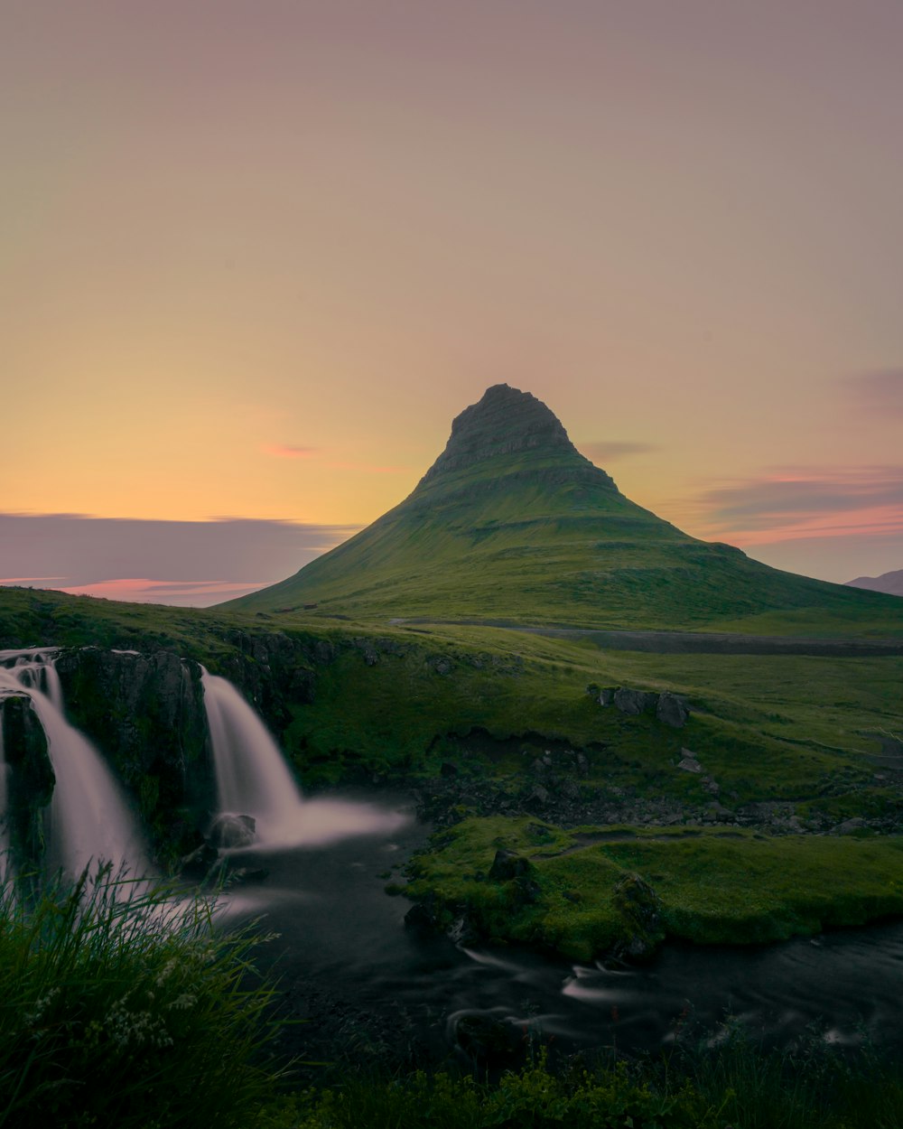 a waterfall with a mountain in the background