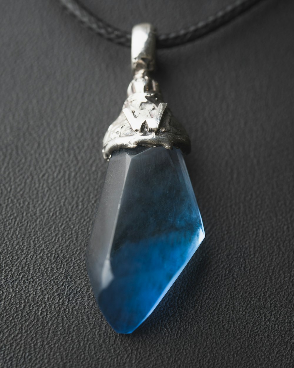 un collar con una piedra azul colgando de él