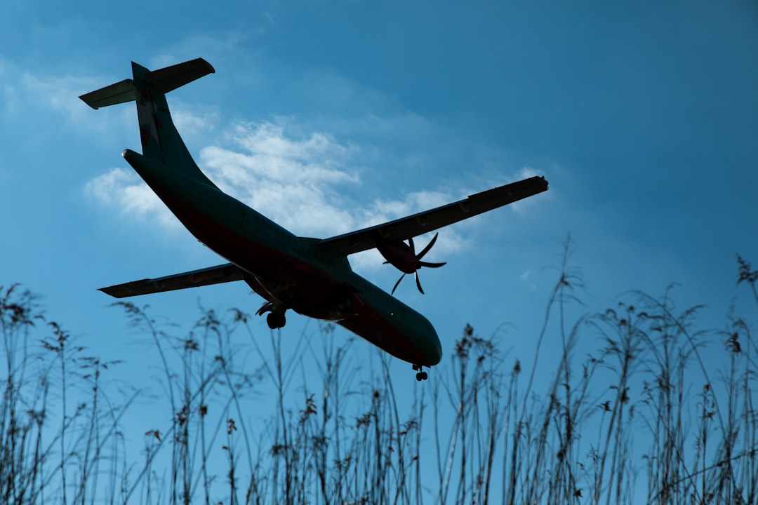 a large airplane flying through a blue sky, Arrival