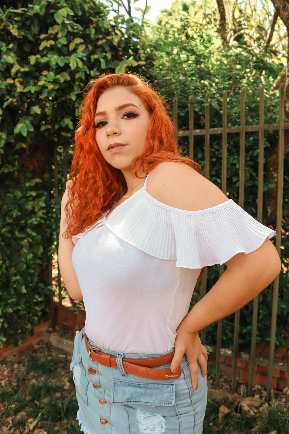 a woman with red hair wearing a white top