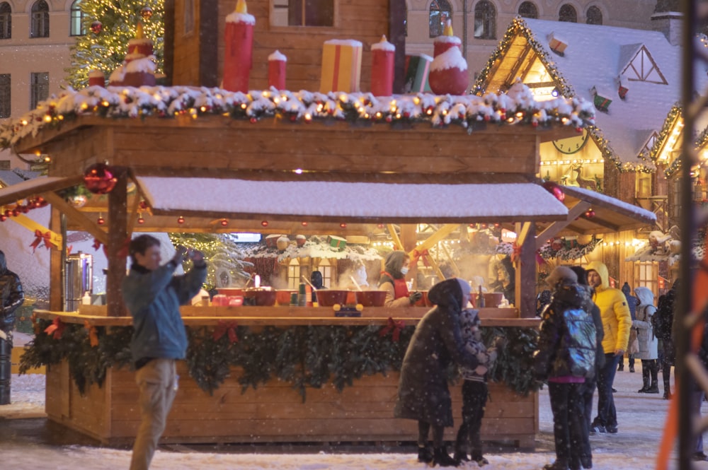 a group of people standing around a christmas market