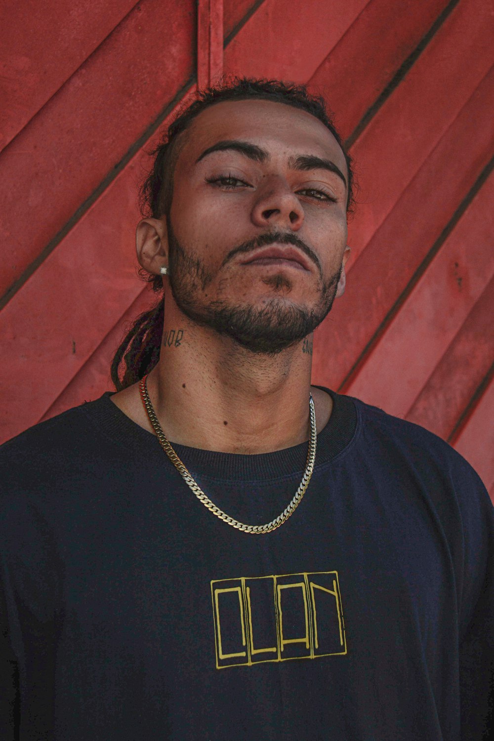 a man wearing a black shirt with a gold chain around his neck