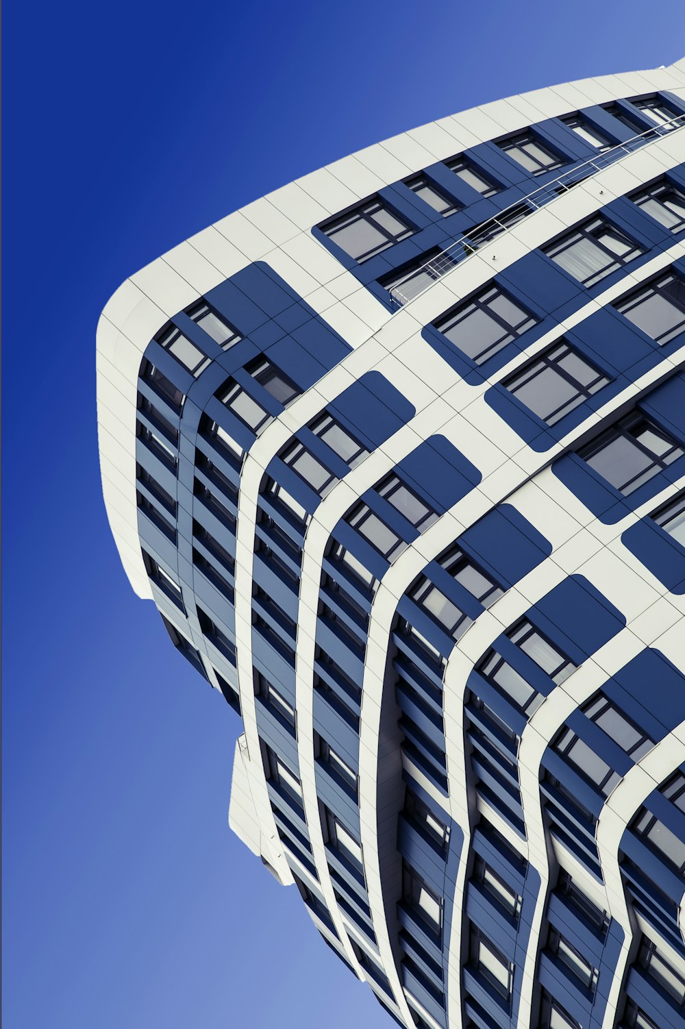 a tall building with many windows against a blue sky