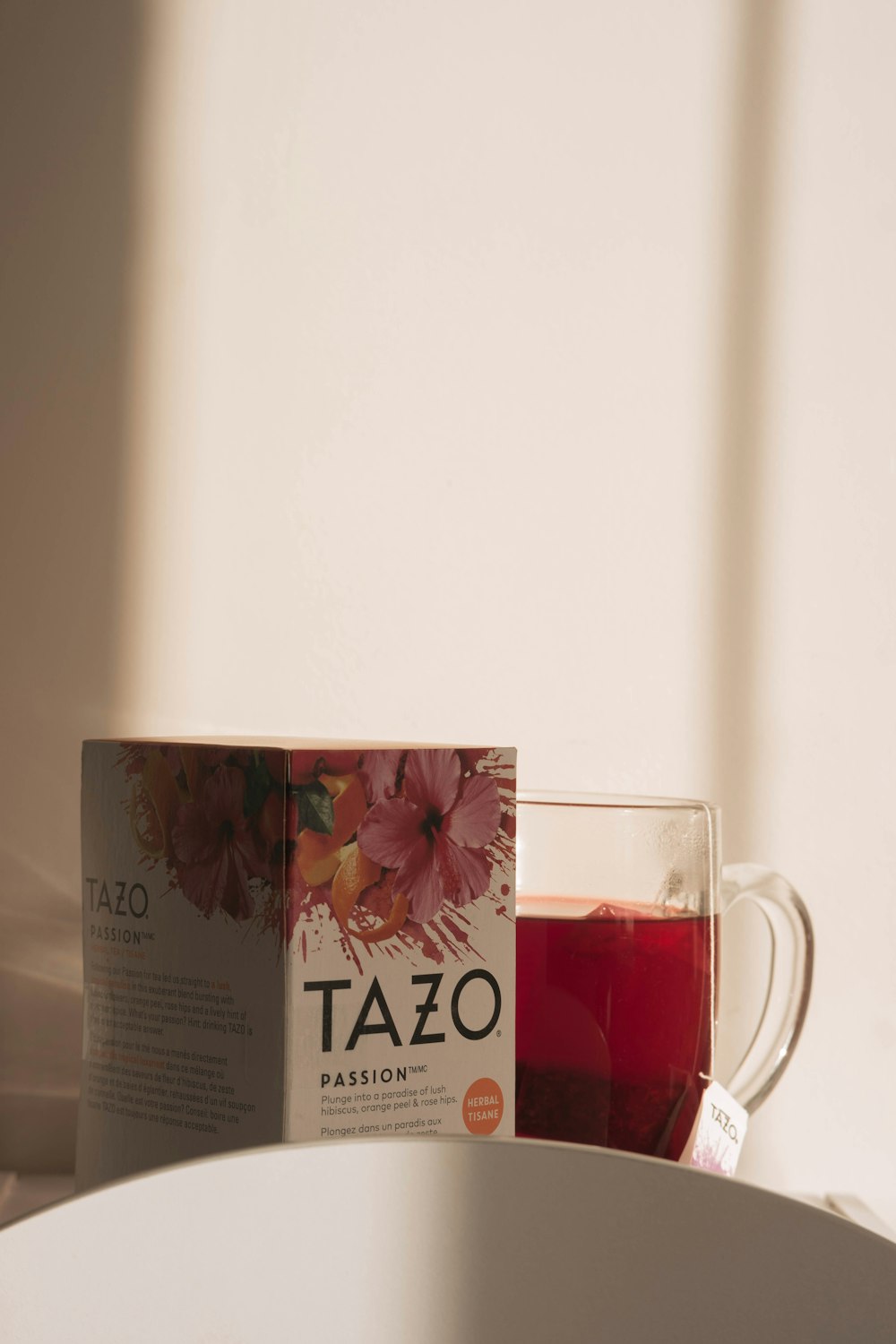 a cup of tea next to a box of tazo