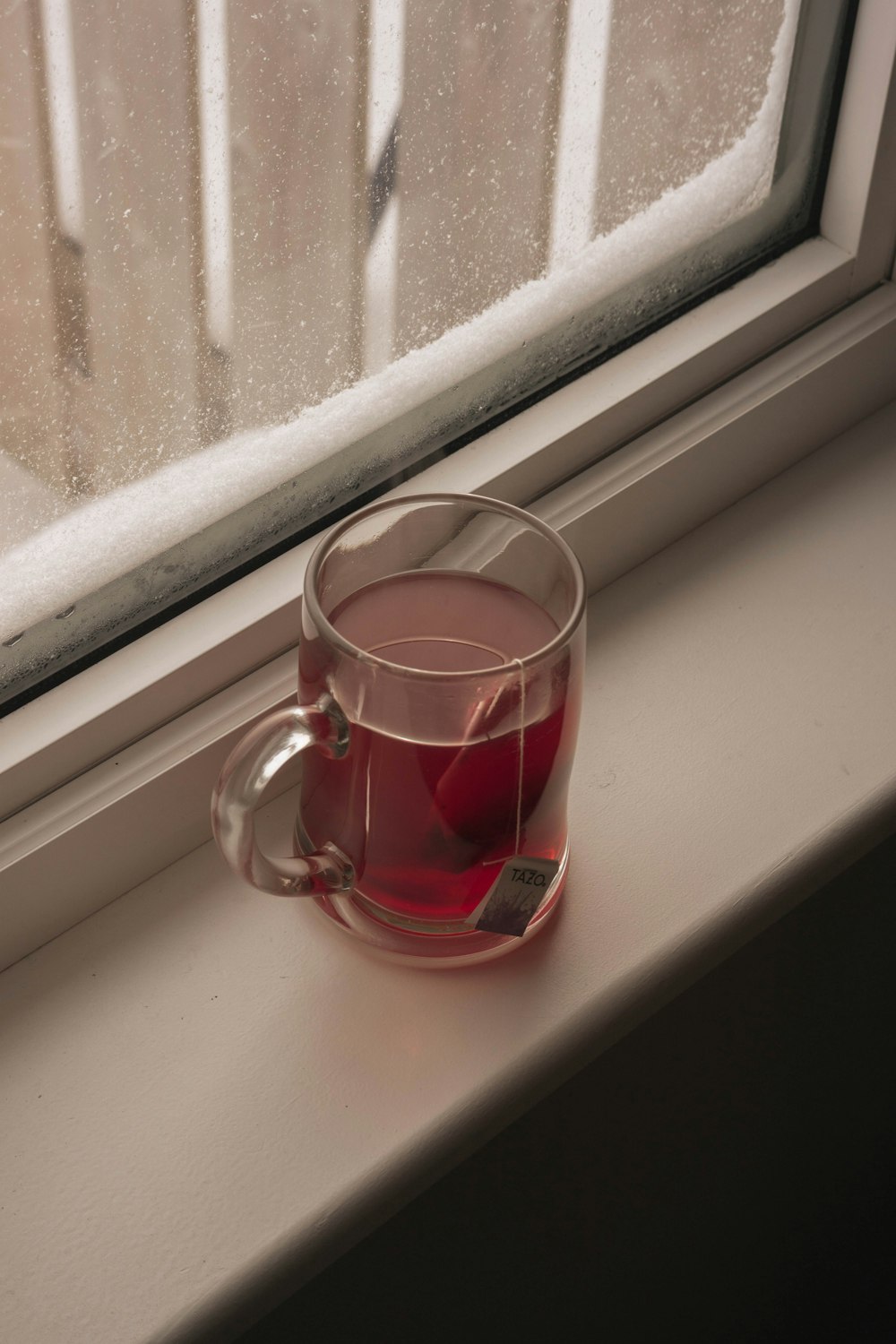 a cup of tea sitting on a window sill