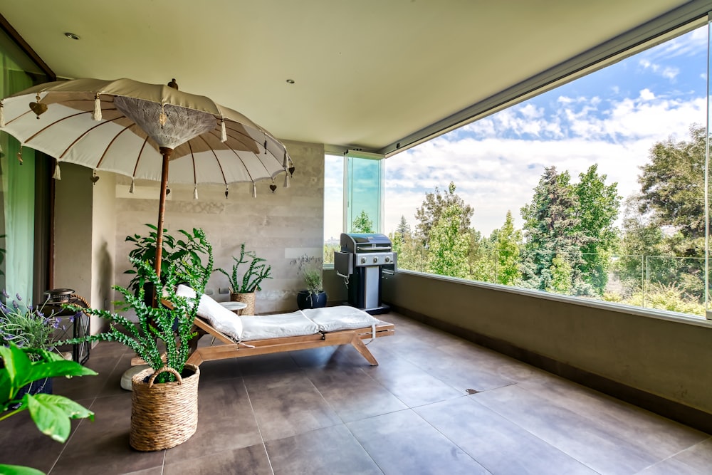 a patio with an umbrella and a chaise lounge