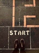 a person standing on a sidewalk with the words life start painted on it
