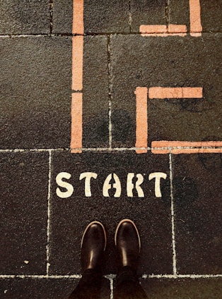 a person standing on a sidewalk with the words life start painted on it