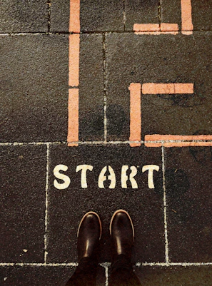 a person standing on a sidewalk with the words life start painted on it