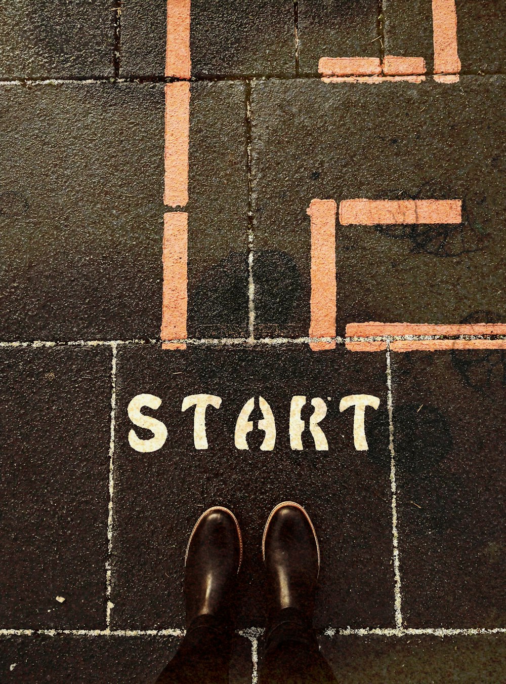 a person standing on a sidewalk with the words life start painted on it