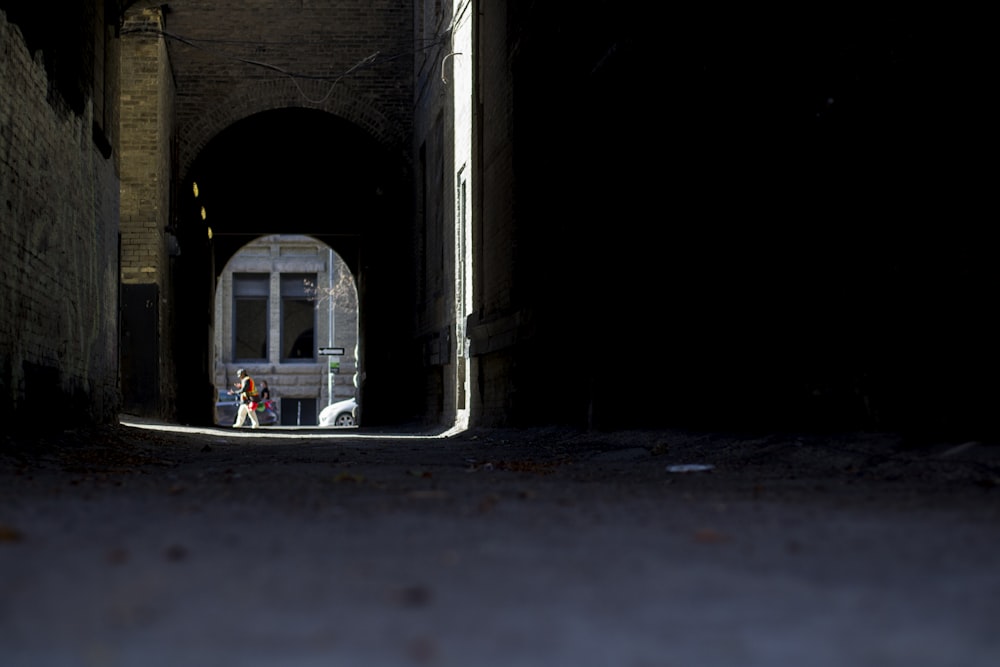 a person standing in a tunnel next to a train