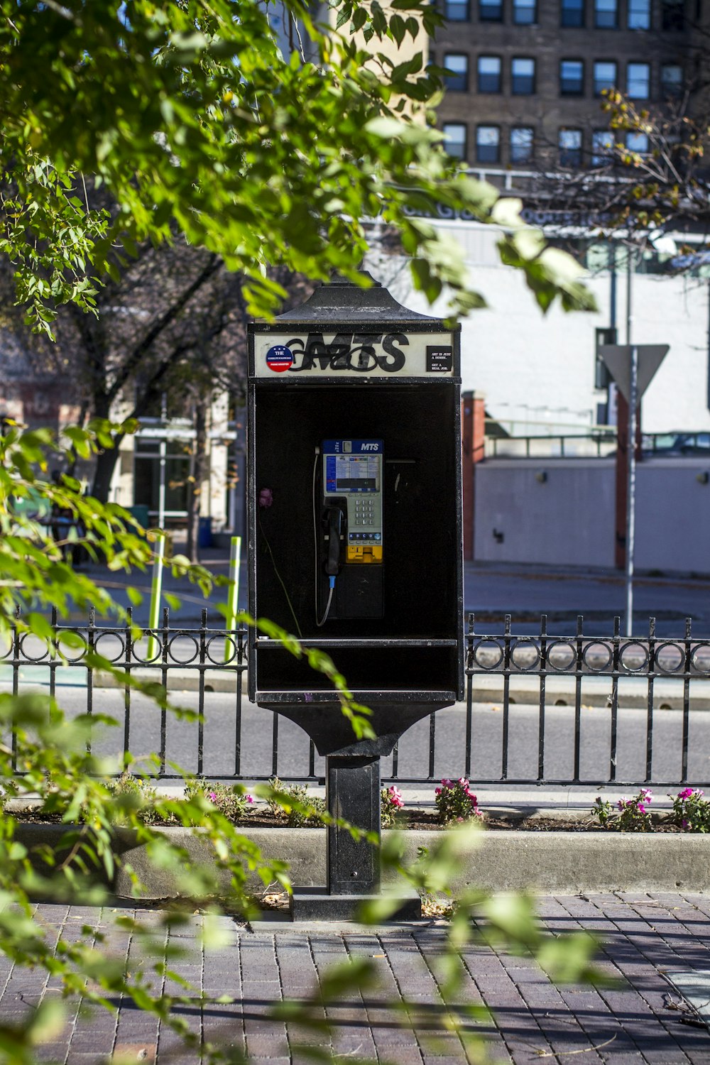 a public phone booth sitting on the side of a road