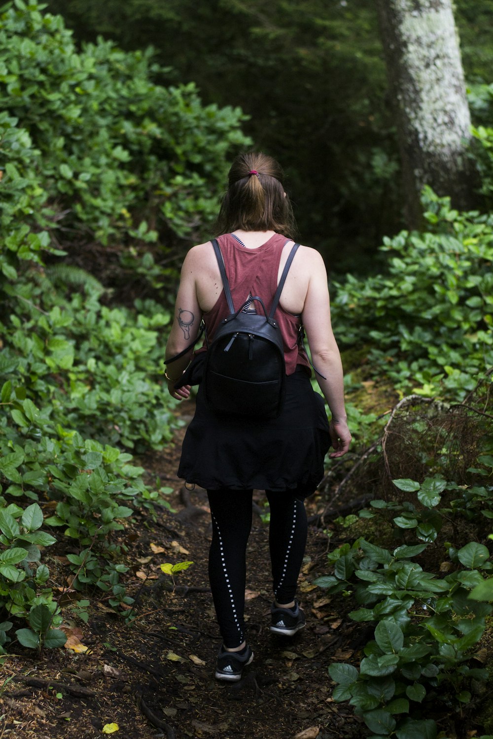 a woman with a backpack walks through the woods