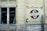 A brick wall with a large sign painted on it displaying the name 'Silco Industries Ltd.' along with an arrow pointing towards the entrance at 70 Arthur St. The wall is part of an older building with two large windows and visible pipes, adding an industrial vibe.