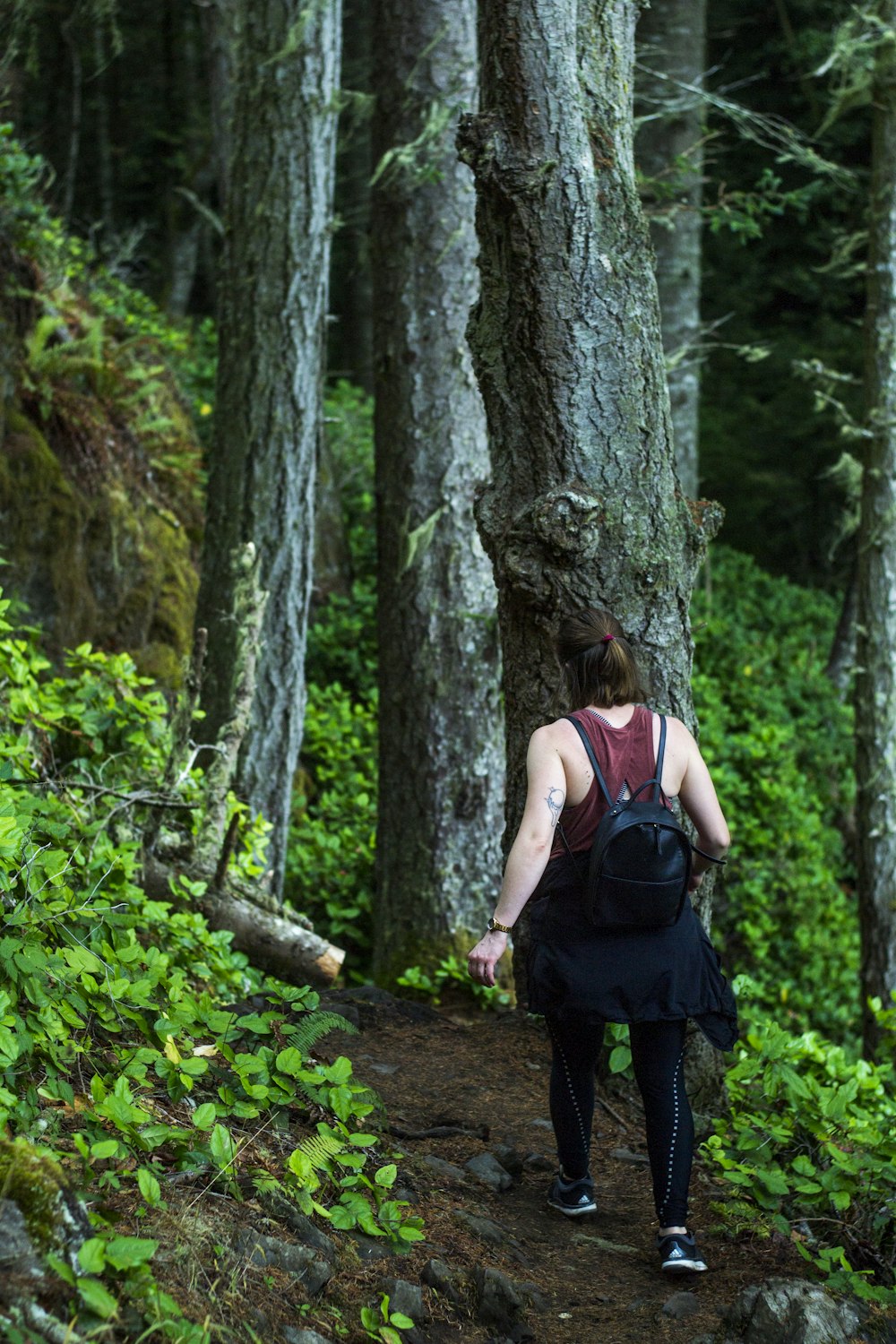 a woman hiking up a trail in the woods