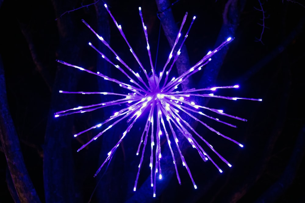 a purple starburst is lit up in the dark