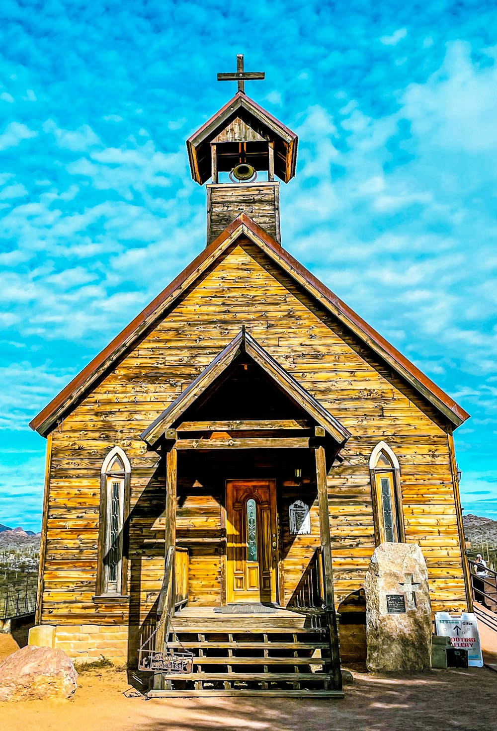 uma pequena igreja de madeira com uma cruz no topo