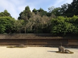 A serene Japanese-style zen garden with rocks and raked gravel.
