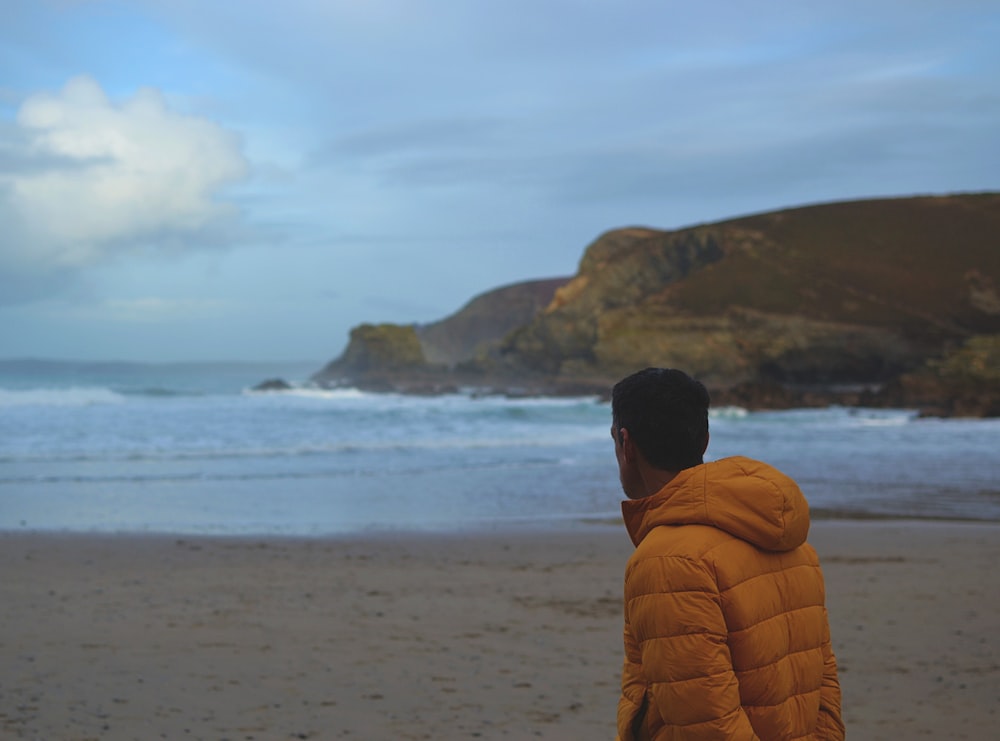 Ein Mann steht am Strand und schaut auf das Meer