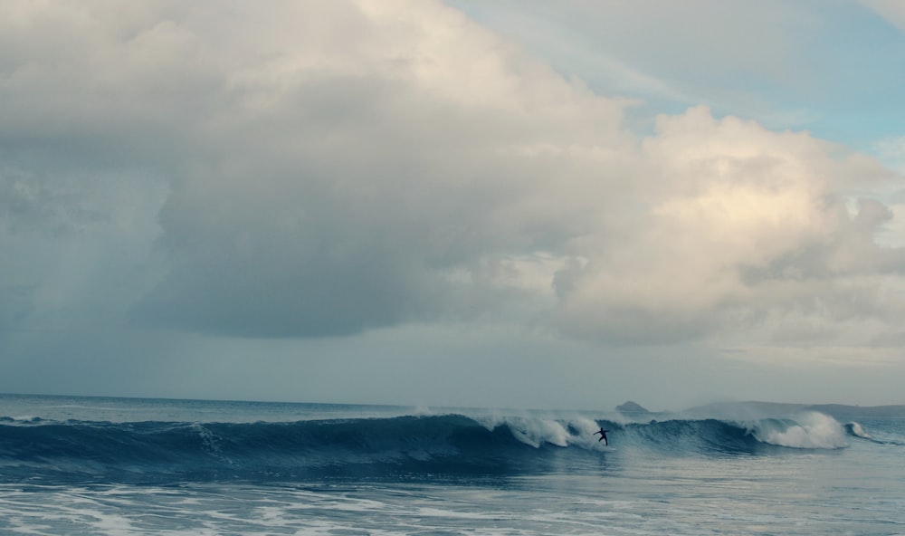 a man riding a wave on top of a surfboard