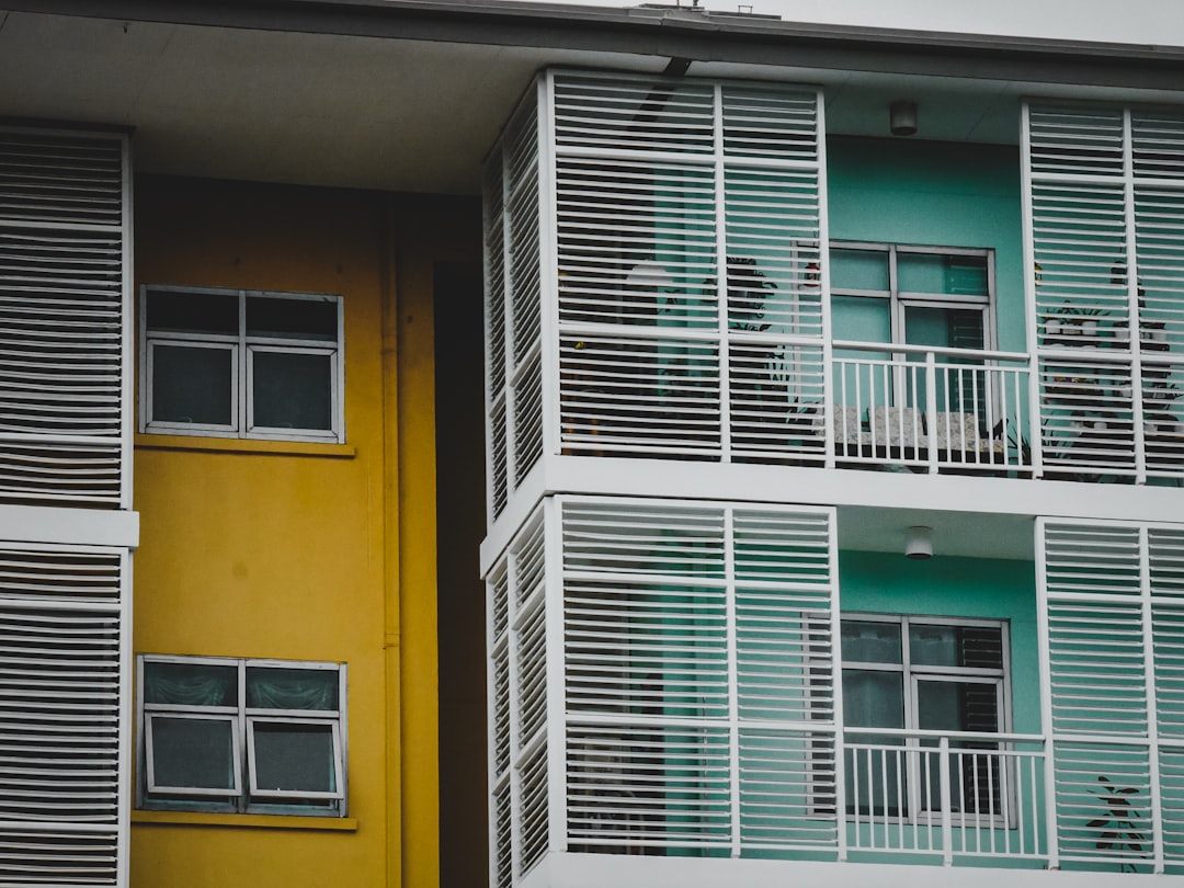 a yellow and green building with two balconies,