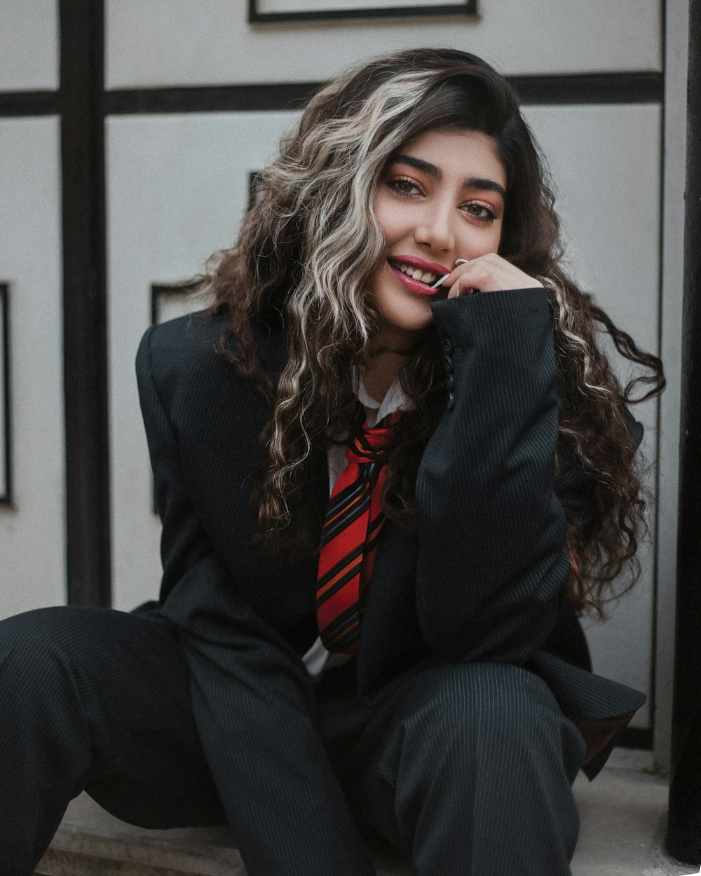 a woman in a suit and tie sitting on a step
