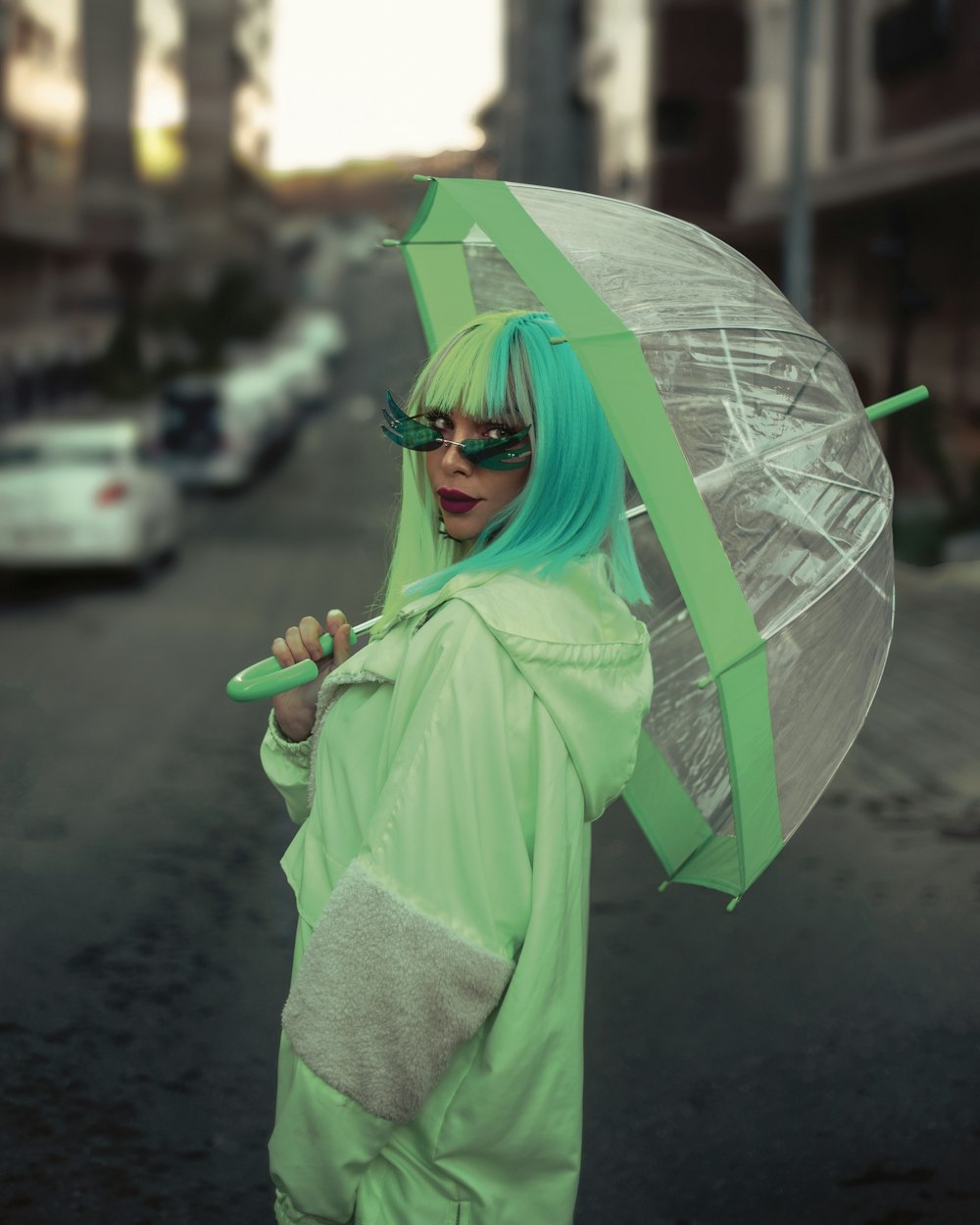 a woman in a green outfit holding an umbrella