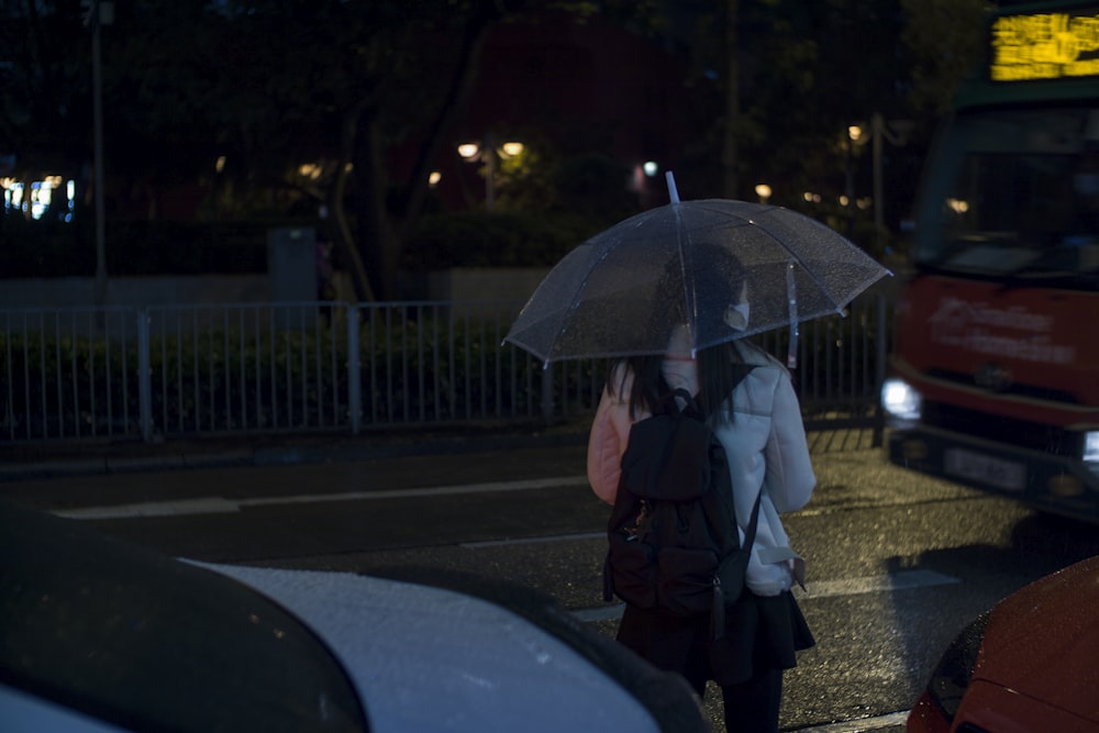 a woman walking down a street holding an umbrella