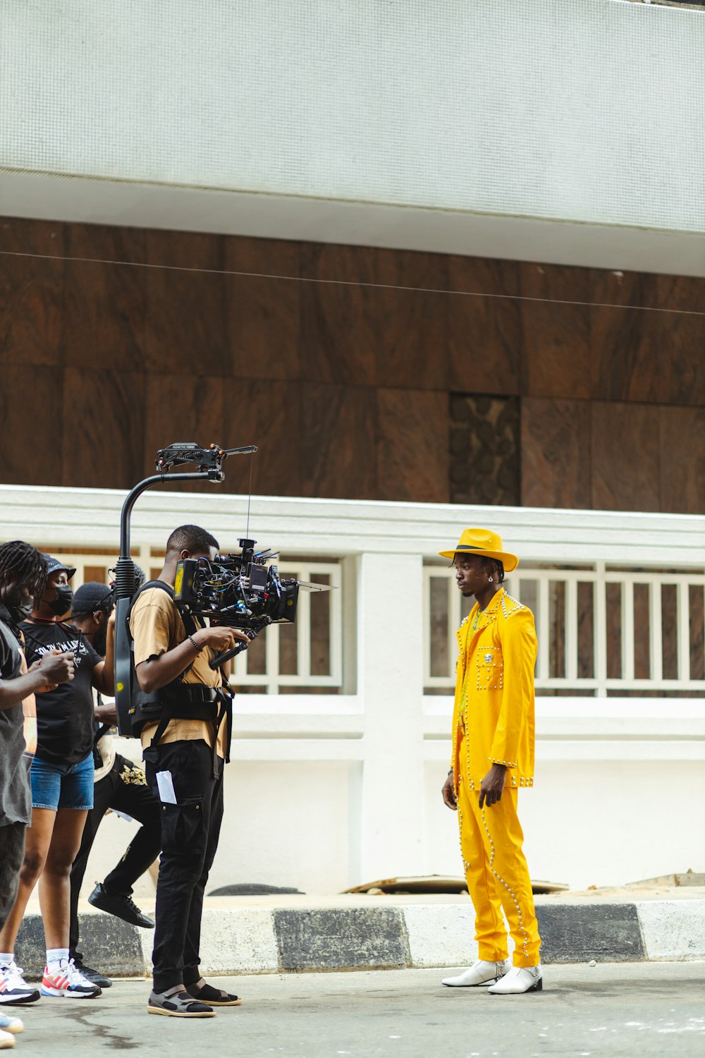 a group of people standing around a man in a yellow suit