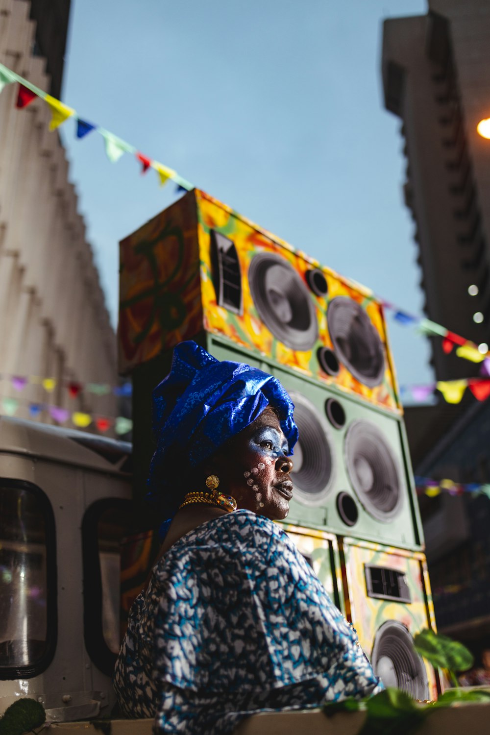 a woman in a blue headdress sitting on a truck